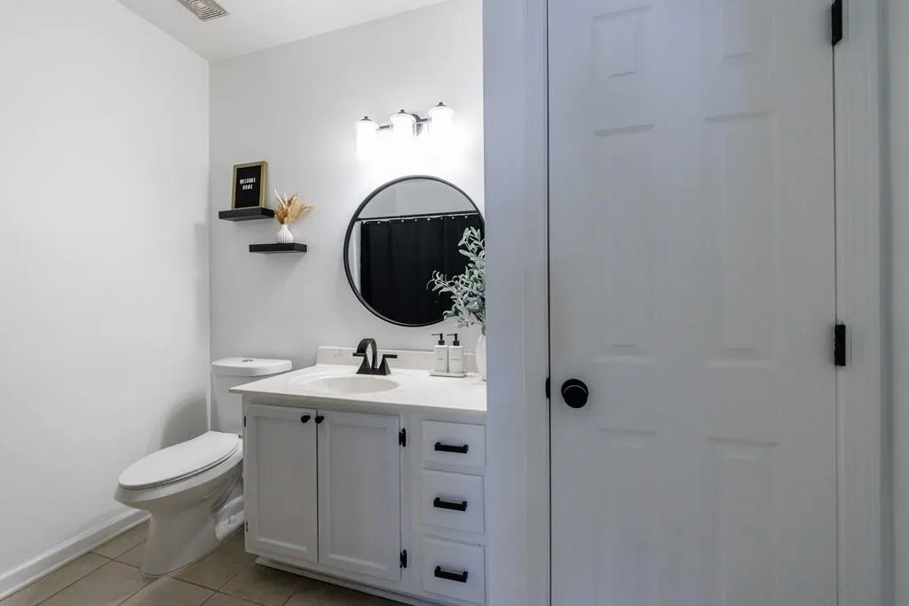 Bathroom with vanity, toilet, and tile patterned flooring