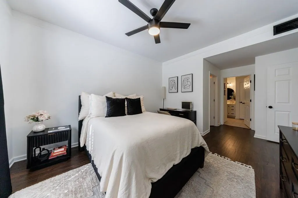Bedroom with crown molding, ensuite bathroom, ceiling fan, and dark hardwood / wood-style flooring