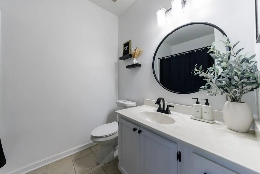 Bathroom featuring vanity, tile patterned floors, and toilet