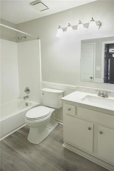 Bathroom with vanity, wainscoting, washtub / shower combination, and wood finished floors