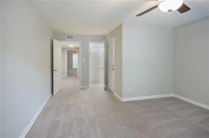 Empty room featuring light carpet and ceiling fan