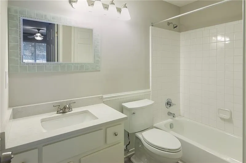 Full bathroom with wainscoting, vanity, and shower / washtub combination