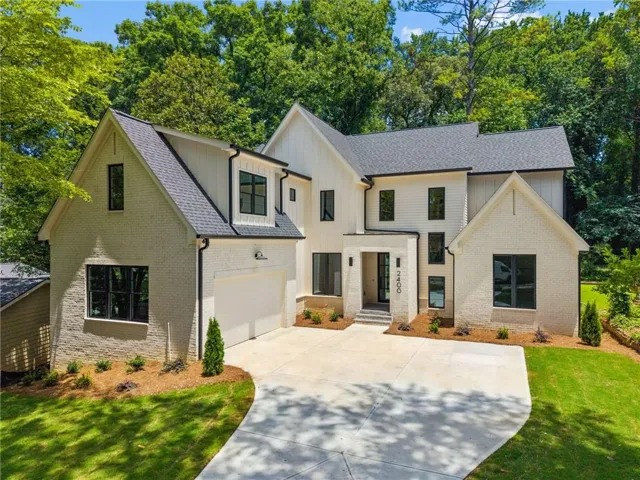 Modern farmhouse-style residence featuring a light brick facade and dark-framed windows
