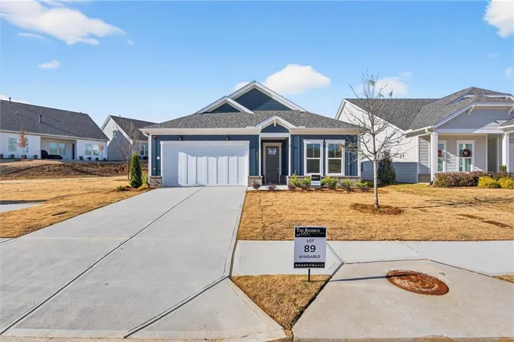 Contemporary single-story residence featuring a dark blue exterior, white trim, and a prominent front-facing garage