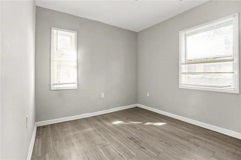 Corridor featuring dark wood-type flooring and baseboards