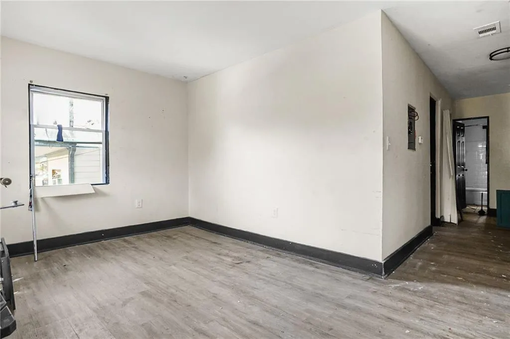 Unfurnished room with wood finished floors and baseboards