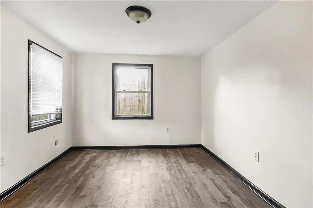 Spare room featuring wood finished floors and baseboards
