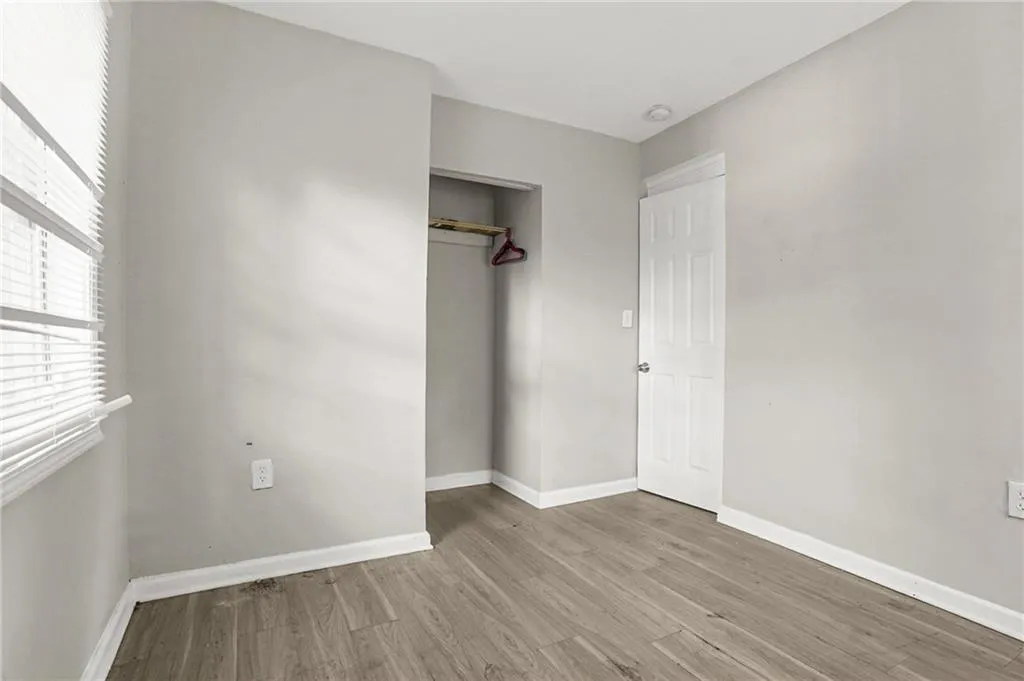 Corridor featuring dark wood-type flooring and baseboards