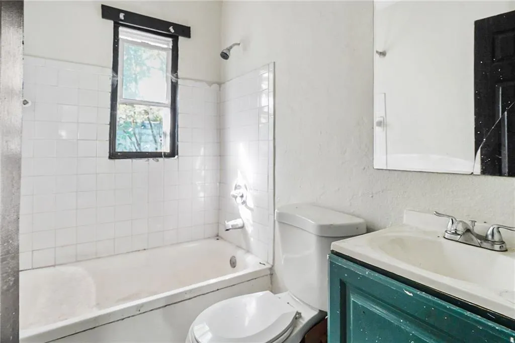 Full bath featuring vanity, shower / washtub combination, and a textured wall