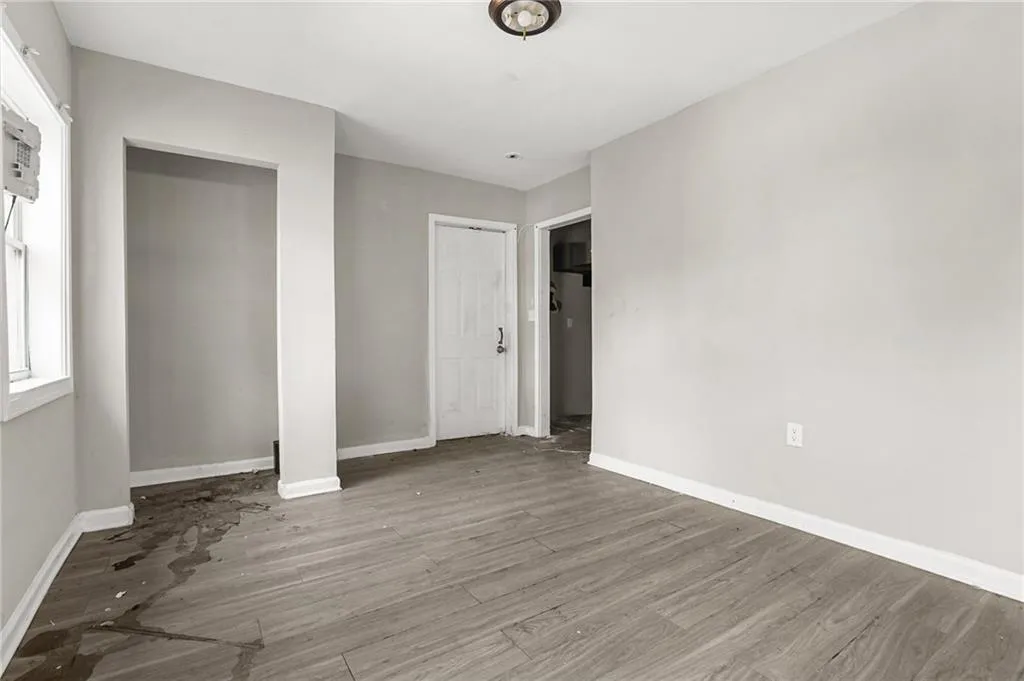 Unfurnished bedroom featuring wood finished floors and baseboards