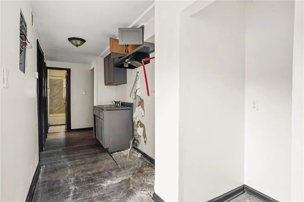 Corridor featuring dark wood-type flooring and baseboards