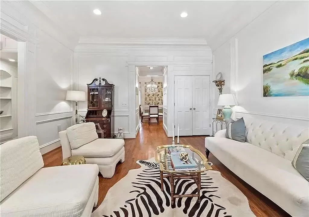 Living room featuring hardwood / wood-style flooring, crown molding, and a chandelier