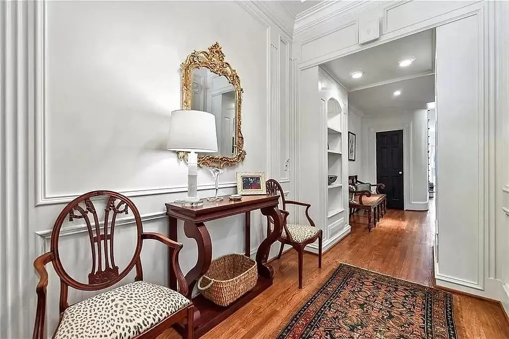 Sitting room featuring wood-type flooring, built in features, and crown molding