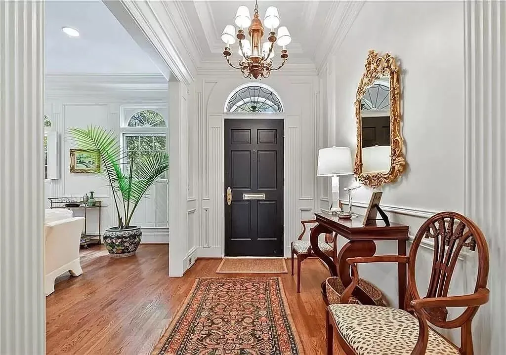 Entryway featuring ornamental molding, wood-type flooring, and a chandelier