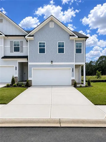 Contemporary townhome exterior featuring light blue shake siding and white trim