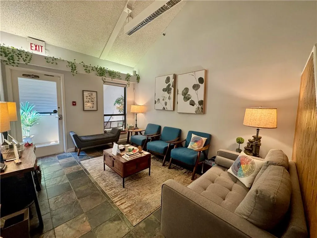 Reception with high vaulted ceiling, and stone tile flooring