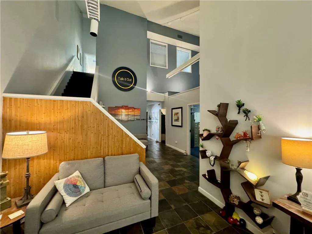 Reception with a towering ceiling, stairs, and tile stone floors