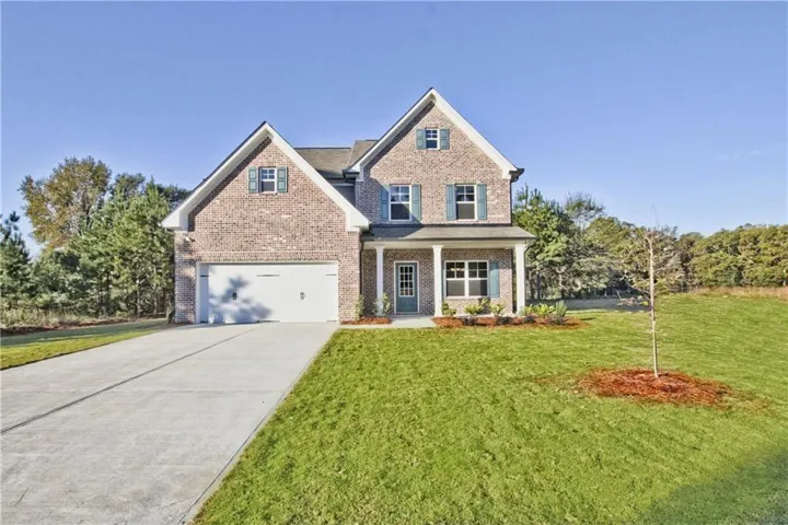 View of front facade featuring a garage and a front lawn