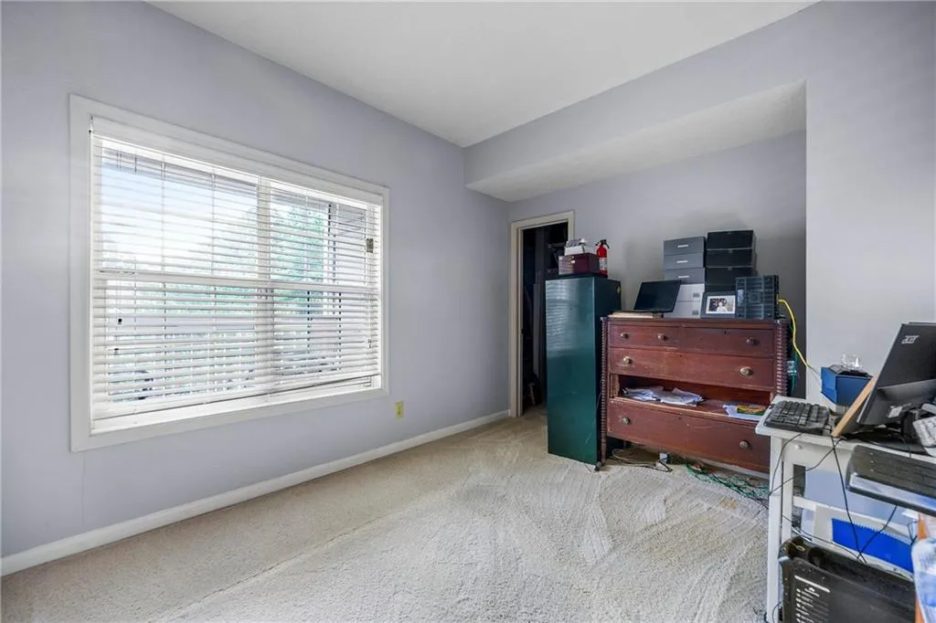 Office area featuring light carpet and baseboards