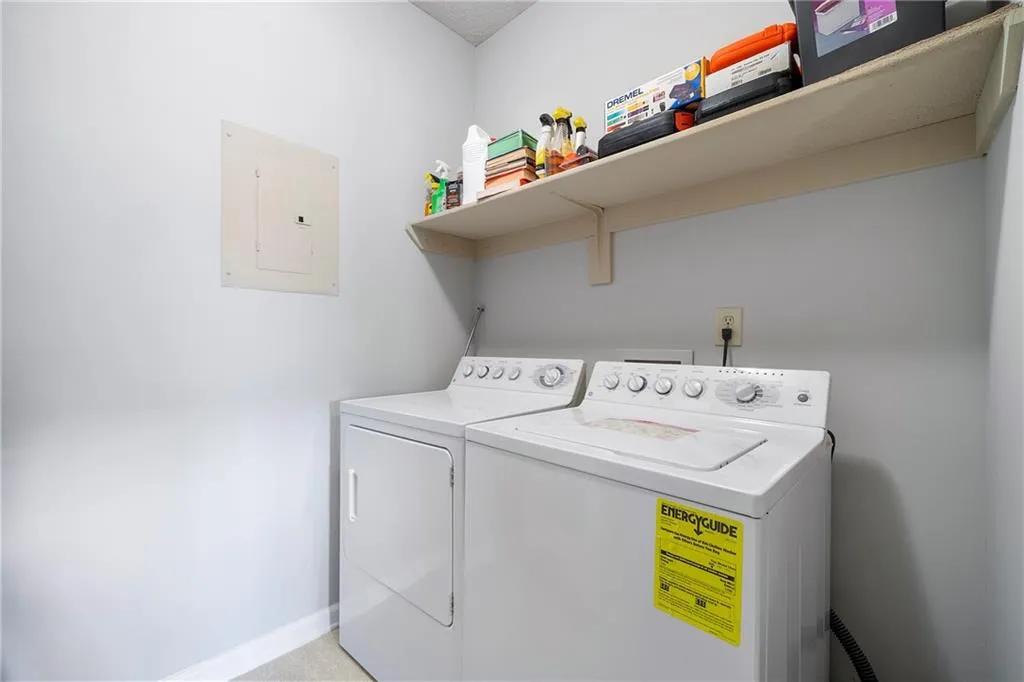 Laundry room featuring electric panel and washing machine and clothes dryer