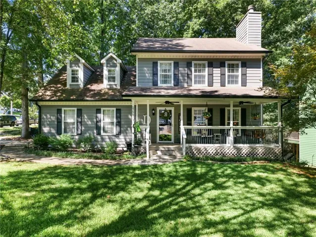 Two-story residence with dormer windows, a covered front porch, and a prominent chimney structure