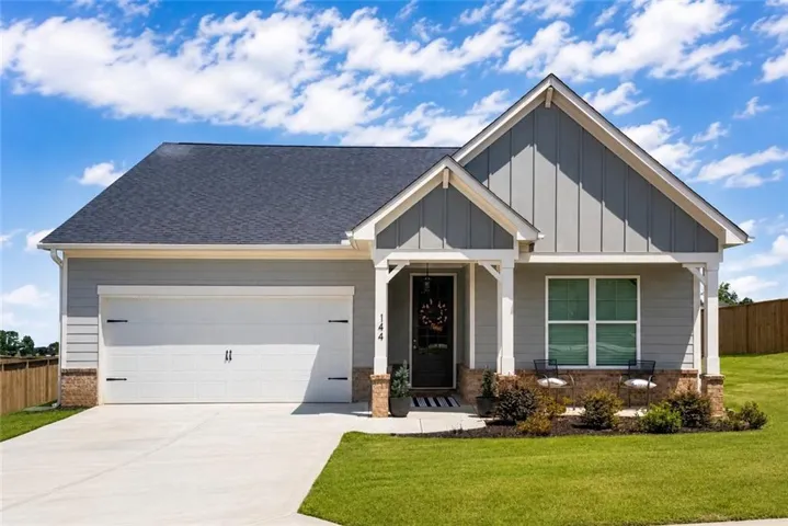 Single-story residence featuring light gray siding with brick accents and a dark gray shingled roof
