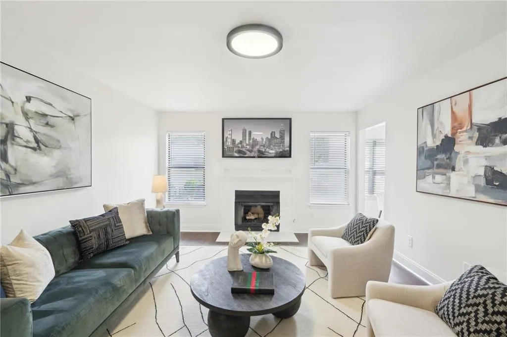 Living area with wood finished floors, a glass covered fireplace, and a healthy amount of sunlight