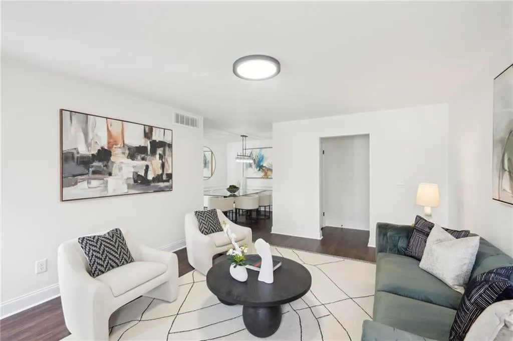Living room featuring visible vents, baseboards, and wood finished floors