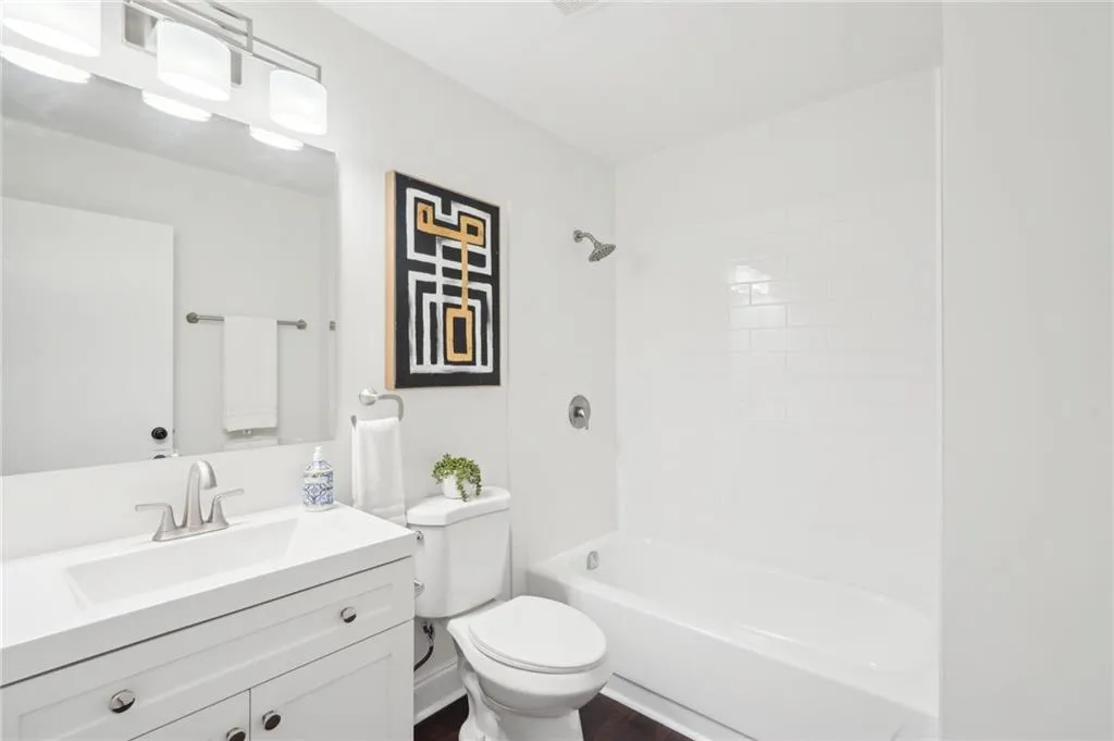 Full bathroom featuring toilet, wood finished floors, vanity, and bathing tub / shower combination
