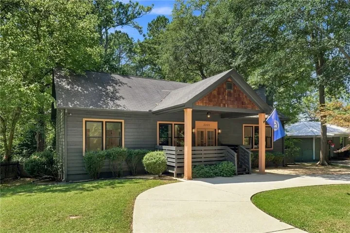 Exterior featuring dark gray siding, a covered entry with wood posts, and a front gable with wood shake siding