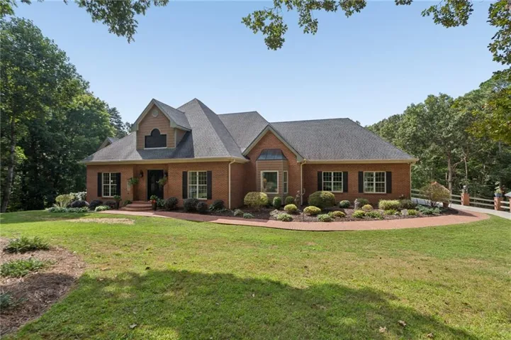 Brick exterior with a prominent dormer, dark-shingle roofing, and a bay window