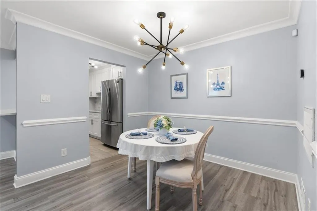 Dining area featuring modern lighting, crown molding, and light wood-style floors