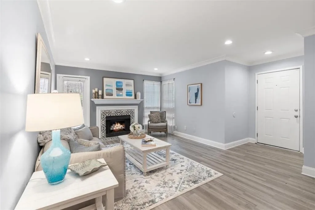 Living area featuring ornamental molding, a tile fireplace, newer luxury, vinyl flooring, and recessed lighting