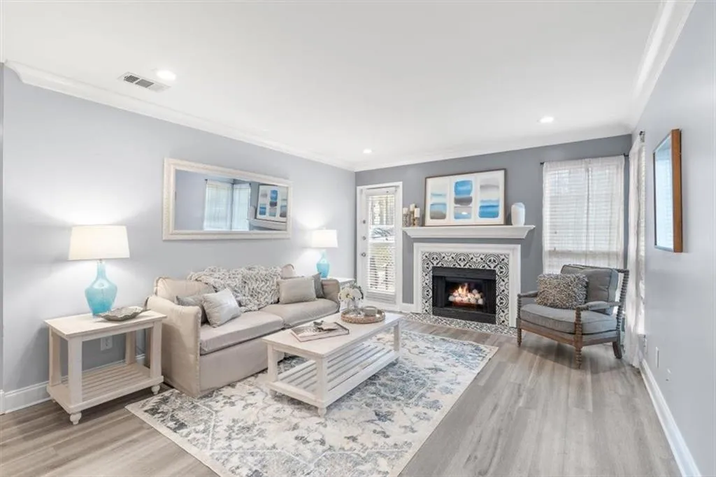 Living room featuring crown molding, a gas fireplace, and recessed lighting