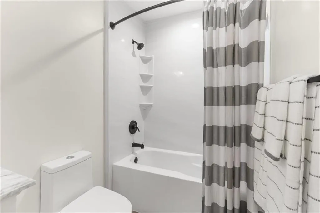 Full bath with shower / tub combo with curtain and low flow toilet