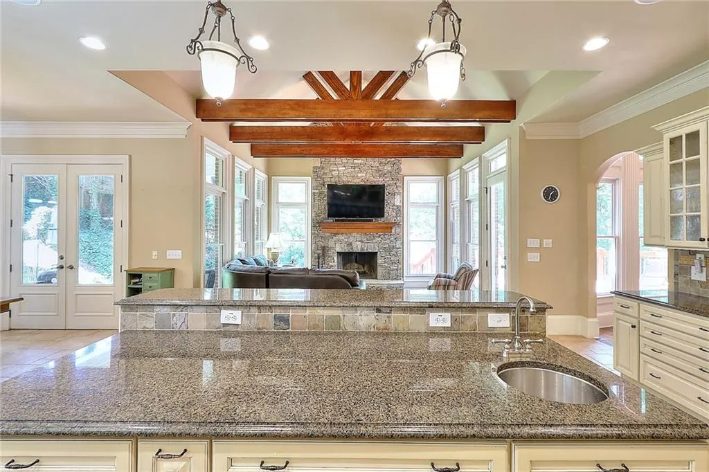 Kitchen with dark stone countertops, sink, decorative light fixtures, and a fireplace