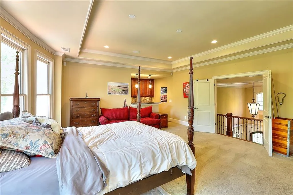 Carpeted bedroom with a raised ceiling and ornamental molding