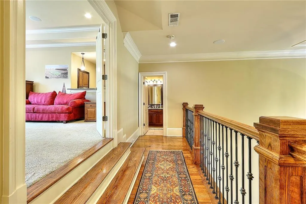 Hall with crown molding and light carpet