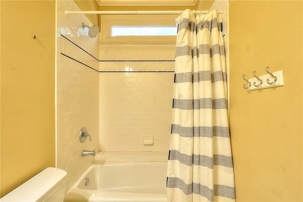 Bathroom with shower / tub combo with curtain and toilet