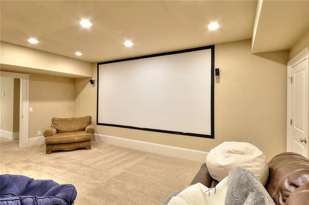 Home theater room featuring light colored carpet