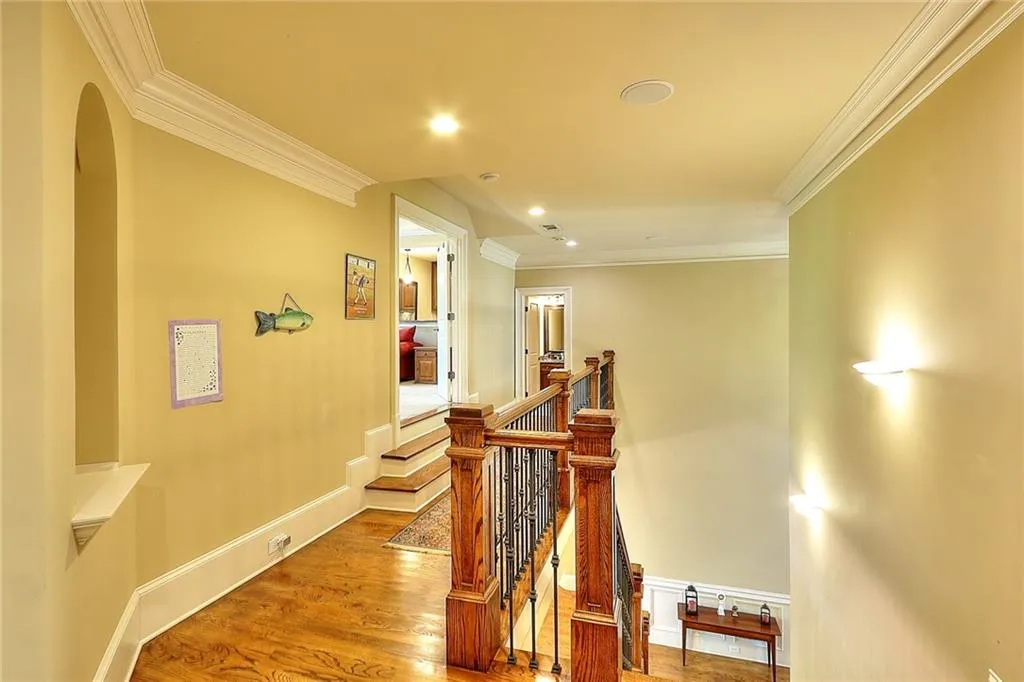 Staircase with dark hardwood / wood-style flooring and crown molding