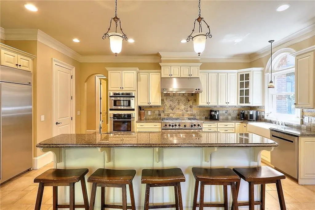 Kitchen with a kitchen island, light tile floors, stainless steel appliances, and tasteful backsplash