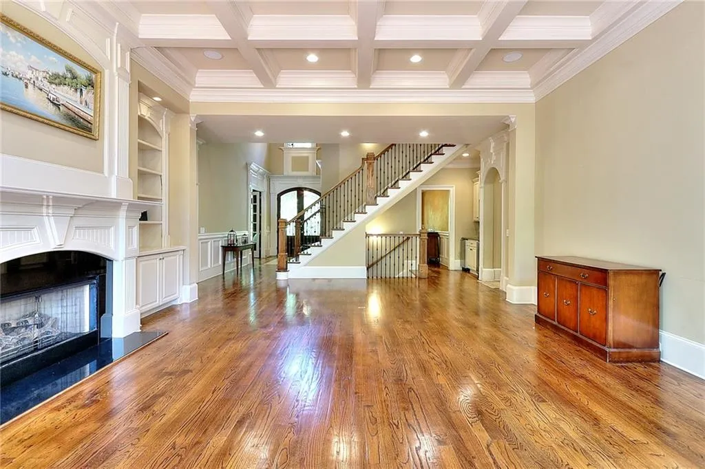 Unfurnished living room featuring coffered ceiling, dark hardwood / wood-style floors, and beamed ceiling