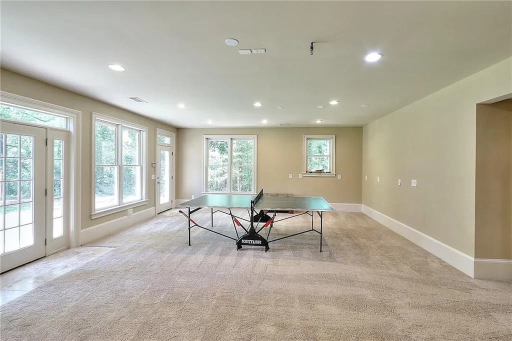 Game room with plenty of natural light and light carpet