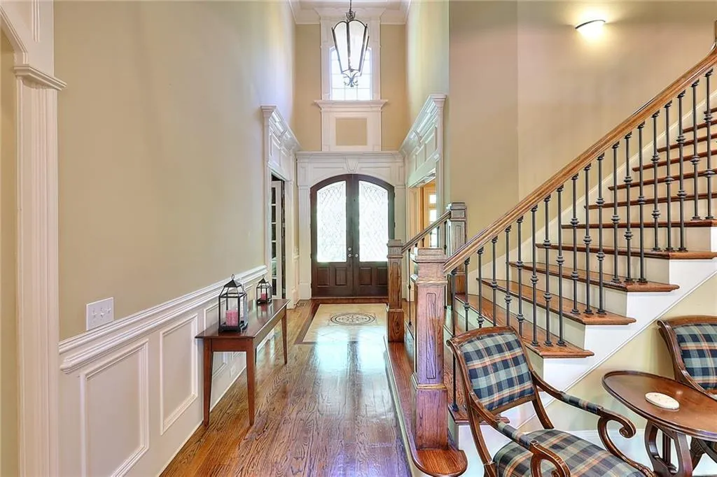 Foyer featuring dark wood-type flooring, a high ceiling, ornamental molding, and french doors