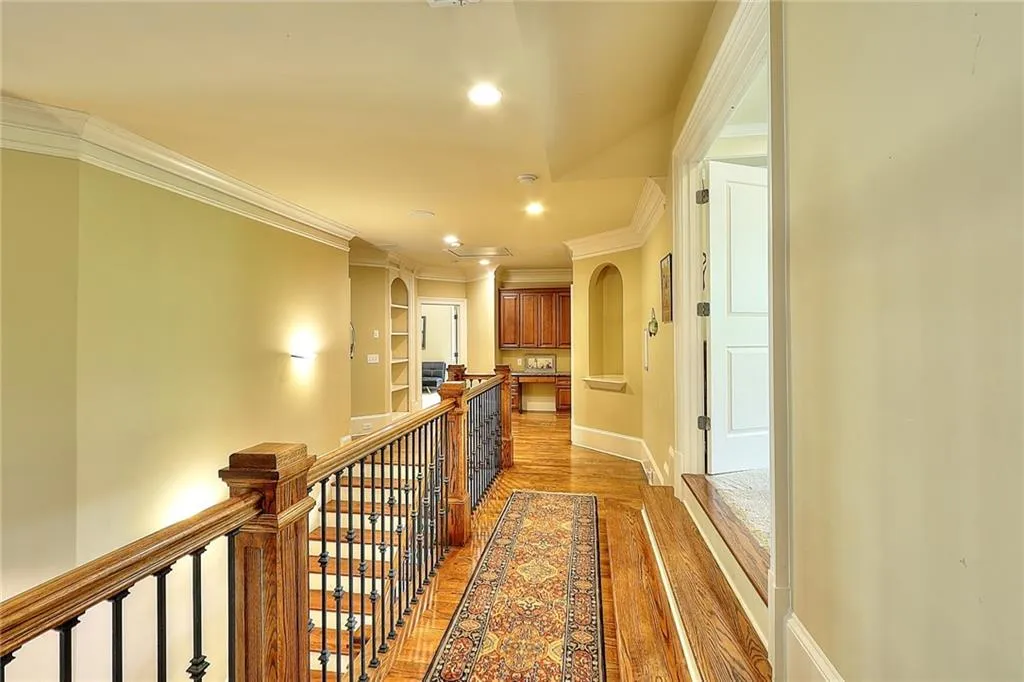 Hall with dark wood-type flooring and crown molding