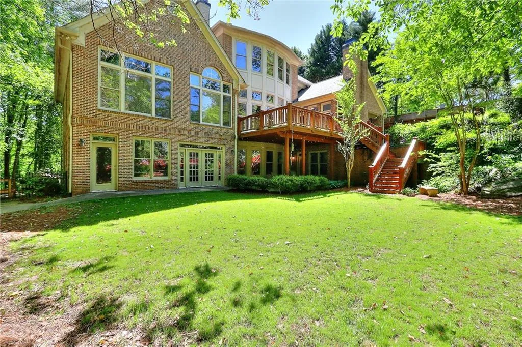 Rear view of property with a wooden deck, french doors, and a yard