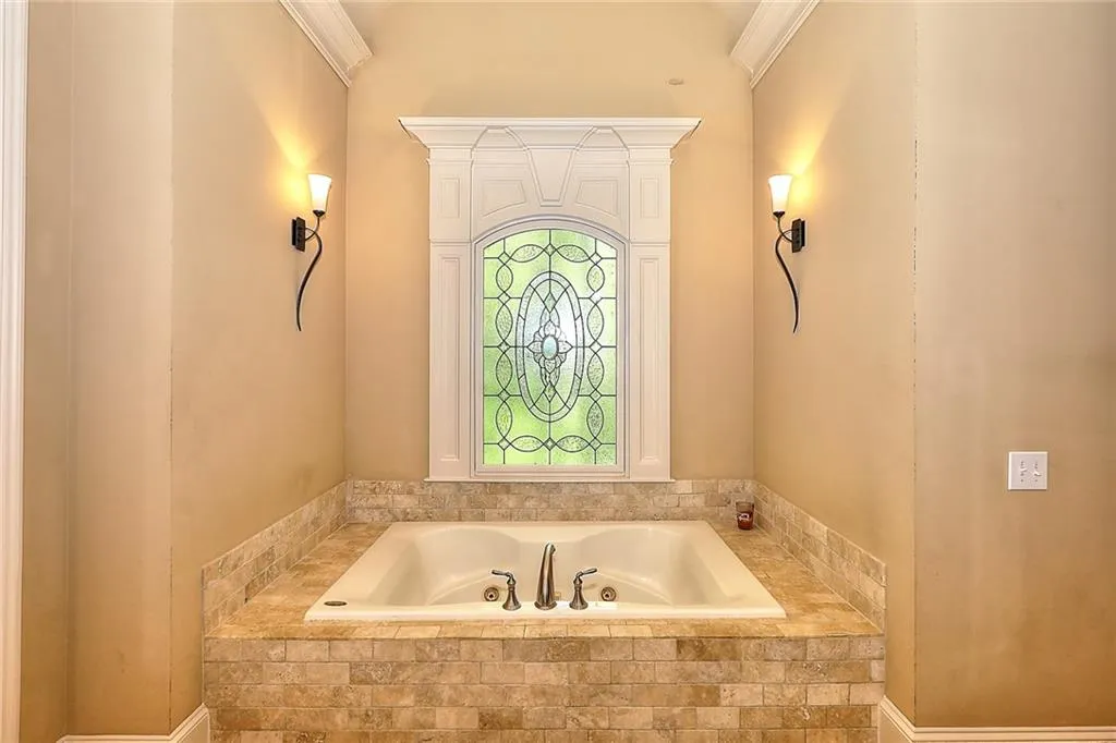 Bathroom with tiled bath and crown molding