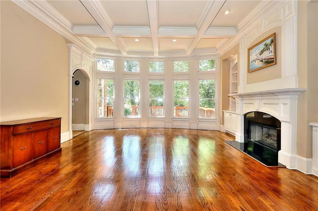Unfurnished living room featuring coffered ceiling, crown molding, dark hardwood / wood-style floors, and beamed ceiling