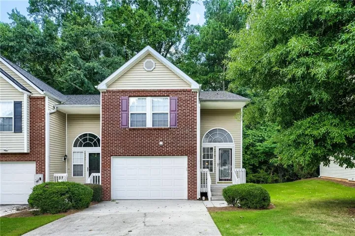 Brick and siding exterior featuring an arched entryway